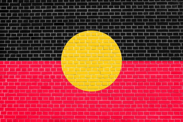 Bandera aborigen australiana en textura de pared de ladrillo — Foto de Stock