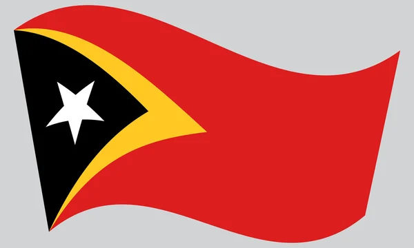 Bandera de Timor Oriental ondeando sobre fondo gris — Vector de stock