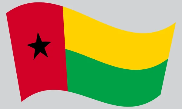 Flag of Guinea-Bissau waving on gray background — Stock vektor