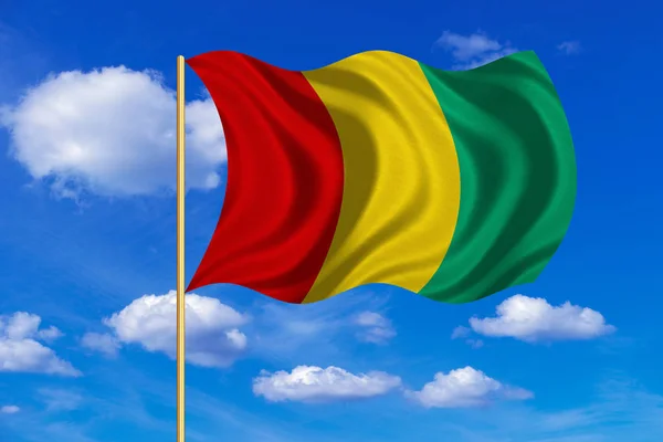 Guineai integet a kék ég háttér zászlaja — Stock Fotó