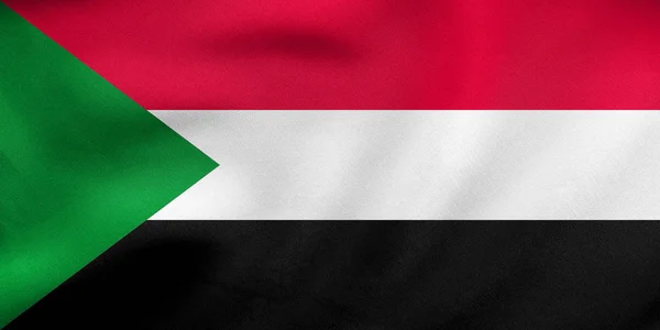 Fahne aus Sudan schwenkend, echte Stoffstruktur — Stockfoto