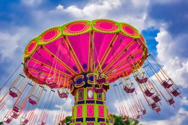 Renkli uçan salıncak binmek lunaparkta