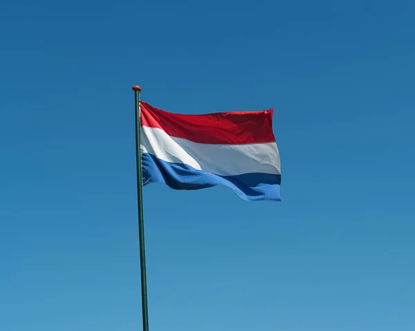 Флаг Нидерландов, размахивающий ветром, голубое небо — стоковое фото