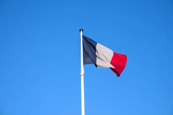 Σημαία της Γαλλίας που κυματίζει στον άνεμο, φόντο μπλε του ουρανού — Φωτογραφία Αρχείου
