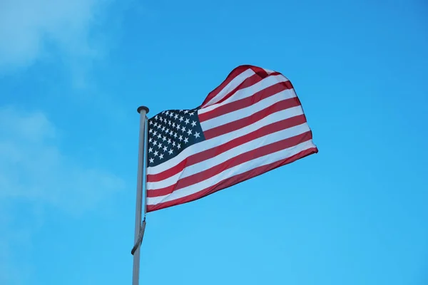 ABD mavi gökyüzü arka plan üzerinde rüzgarda sallayarak bayrak — Stok fotoğraf