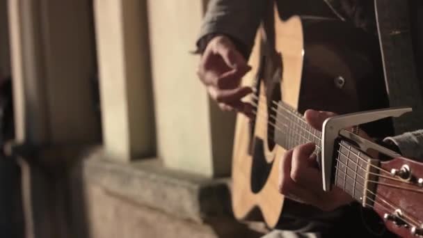 Чоловік грає на гітарі на вулиці. — стокове відео
