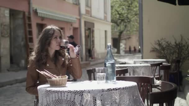 Молодая девушка пьет красное вино — стоковое видео