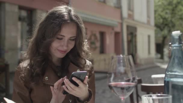 Chica joven usando su teléfono inteligente en el café — Vídeo de stock