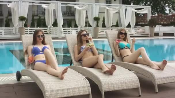 Молодые девушки отдыхают у бассейна — стоковое видео