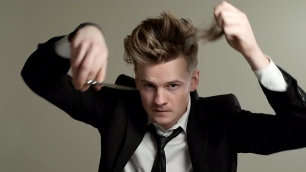Chlápek si stříhá vlasy nůžkami. — Stock video