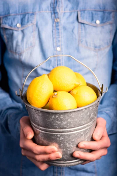 lemons bucket in hands