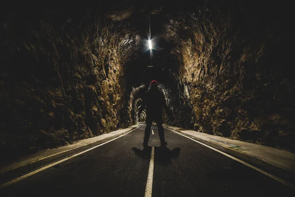 ışıklı bir tünel girişinde duran adam
