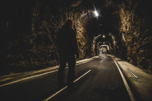 Uomo in piedi all'ingresso di un tunnel illuminato — Foto Stock