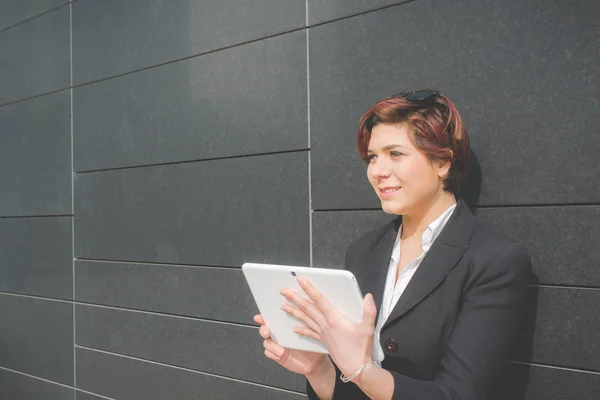 Jonge authentiek zakenvrouw met tablet pc glimlachend in het financiële district voor zakenreis — Stockfoto