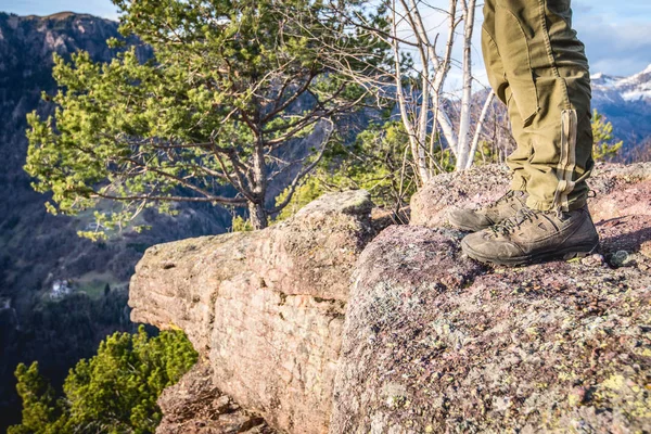 Wandelaar rustend op de klif en overweegt een prachtig berglandschap Stockfoto