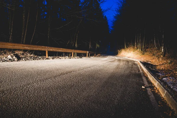 I fari di un'auto sulla strada di montagna di notte — Foto Stock