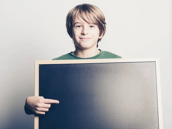 Lilla leende pojke med blackboard — Stockfoto