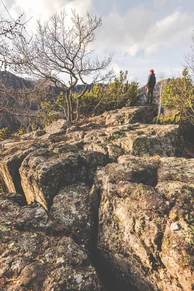 Wandelaar permanent op de rotsen en overweegt een prachtig berglandschap Rechtenvrije Stockafbeeldingen