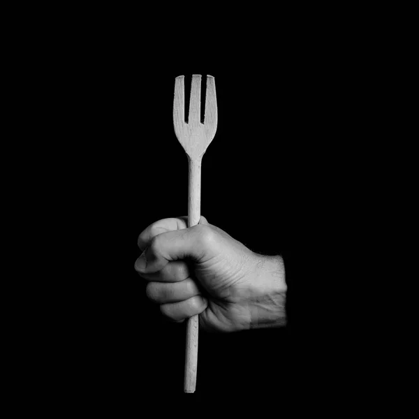 Wooden fork - kitchen tools in a man's hand - black and white photo — Stock Photo, Image