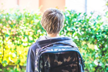 Genç çocuk okula gitmek için evden ayrılmaya hazır. Günlük hayatın yeni günü.