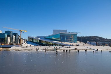 Oslo, Norveç - 27 Şubat 2016: Oslo Opera Evi yürüme ve rahatlatıcı insanlar güneşli kış gününde