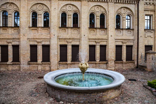 Velha fonte e casa de tijolos em Vilnius, Lituânia — Fotografia de Stock