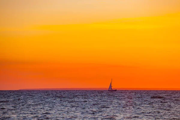 Красивый оранжевый закат и лодка на Балтийском море — стоковое фото