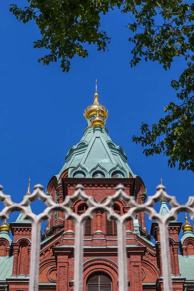 Uspenski Catedral y valla en verano Día soleado. Iglesia Roja - Destino turístico en la capital finlandesa —  Fotos de Stock
