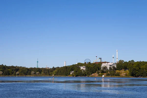 ヘルシンキ, フィンランド - 2015 年 8 月 20 日。パドルボーディング都市公園湖でのリラックス. — ストック写真