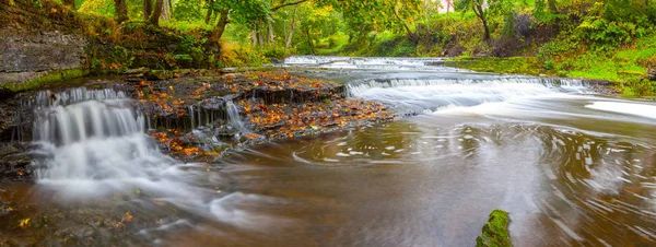 Panoramic view of small waterfall cascades on river in Estonia