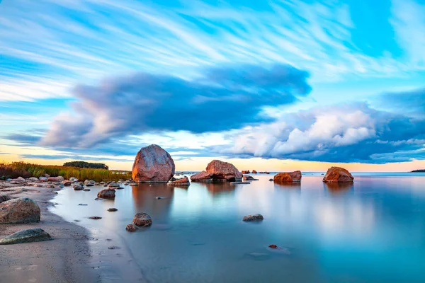 Яркий морской закат с камнями вдоль побережья — стоковое фото