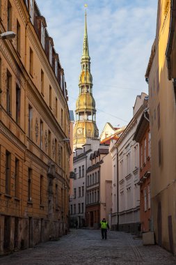 Riga, Letonya - 25 Aralık 2015. İşçi tarafından yürüyüş steet arka plan, St Peters kilise ile eski şehirde dar