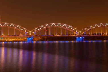 gece ışıklı demiryolu köprüsünde de riga, Letonya