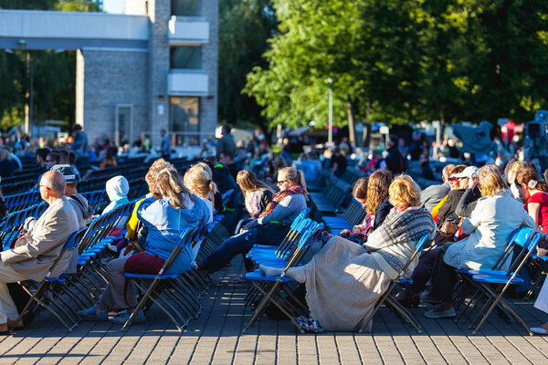 TALLINN, ESTONIA - 04 JUL 2014: People sitting and watching song concert at Tallinn Song Festival Grounds
