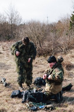 Humala, Estonya - 09 Nisan 2016: kamuflaj silah ile iki adam bir oyunu başlatmak hazırlıyoruz. Askeri taktik airsoft oyun.