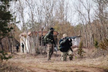 Humala, Estonya - 09 Nisan 2016: kamuflaj silah ile iki asker konumlarını korumak. Askeri taktik airsoft oyun.
