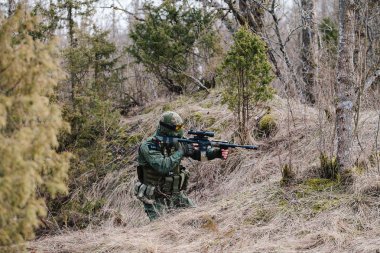 Humala, Estonya - 09 Nisan 2016: kamuflaj silahla asker onun konumunu korumak. Askeri taktik airsoft oyun.