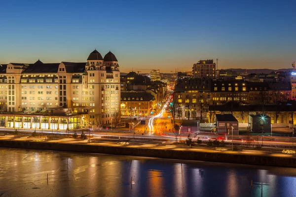 Vue en soirée de la maison et de la circulation sur le front de mer de la ville, éclairée par des veilleuses à Oslo, Norvège . — Photo