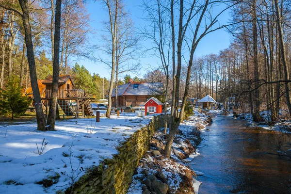 Cabañas de madera en bosque invernal cerca del río. Lugar para descansar y pasar un fin de semana . —  Fotos de Stock