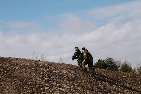 HUMALA, ESTÔNIA - 09 ABR 2016: Três soldados em camuflagem com armas protegem sua posição. Jogo airsoft tático militar . — Fotografia de Stock