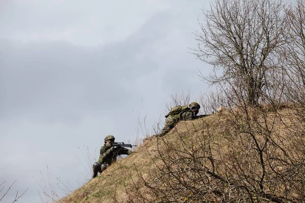 HUMALA, ESTÔNIA - 09 ABR 2016: Dois soldados em camuflagem com armas protegem sua posição. Jogo airsoft tático militar . — Fotografia de Stock