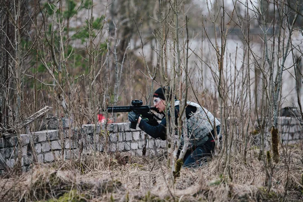 HUMALA, ESTONIA - 09 ABR 2016: Soldado en camuflaje con arma protege su posición. Militar táctica airsoft juego . — Foto de Stock