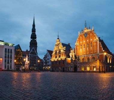 Riga, Letonya - 20 Haziran 2016: City Hall Square siyah nokta ev ve Riga eski kentte Saint Peter kilisesinde gece.