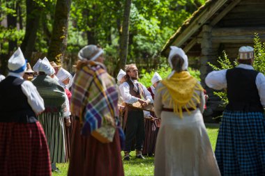 Riga, Letonya - 12 Haziran 2016: Letonyalılar Ulusal kostümleri folklor şarkıları söyleyerek. Letonca Etnografya Müzesi.