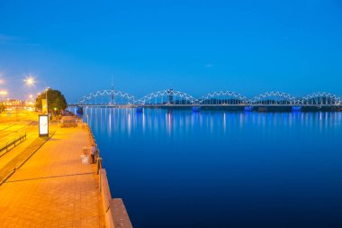 Daugava dolgu ve demiryolu Nehri üzerinde köprü. Gece panoramik sahne Riga, Letonya