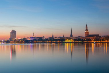 Eski Riga gece manzarası. Işıklı şehir güneş battıktan sonra. Daugava Nehri üzerinden panoramik görünüm