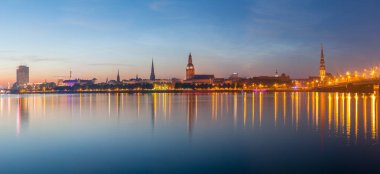 Eski Riga gece manzarası. Işıklı şehir güneş battıktan sonra. Daugava Nehri üzerinden panoramik görünüm