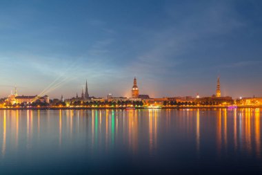 Eski Riga gece manzarası. Işıklı şehir güneş battıktan sonra. Daugava Nehri üzerinden panoramik görünüm