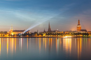 Eski Riga gece manzarası. Işıklı şehir güneş battıktan sonra. Daugava Nehri üzerinden panoramik görünüm