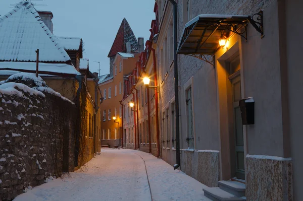 Old Tallinn jalan sempit dengan lentera bersinar. Salju malam musim dingin . — Stok Foto
